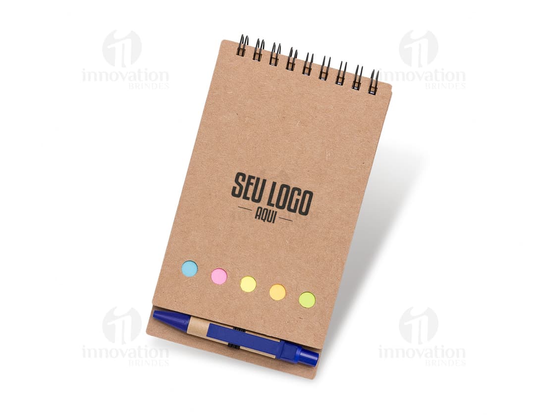 Bloco de anotações de couro marrom com caneta esferográfica preta sobre a mesa de madeira.