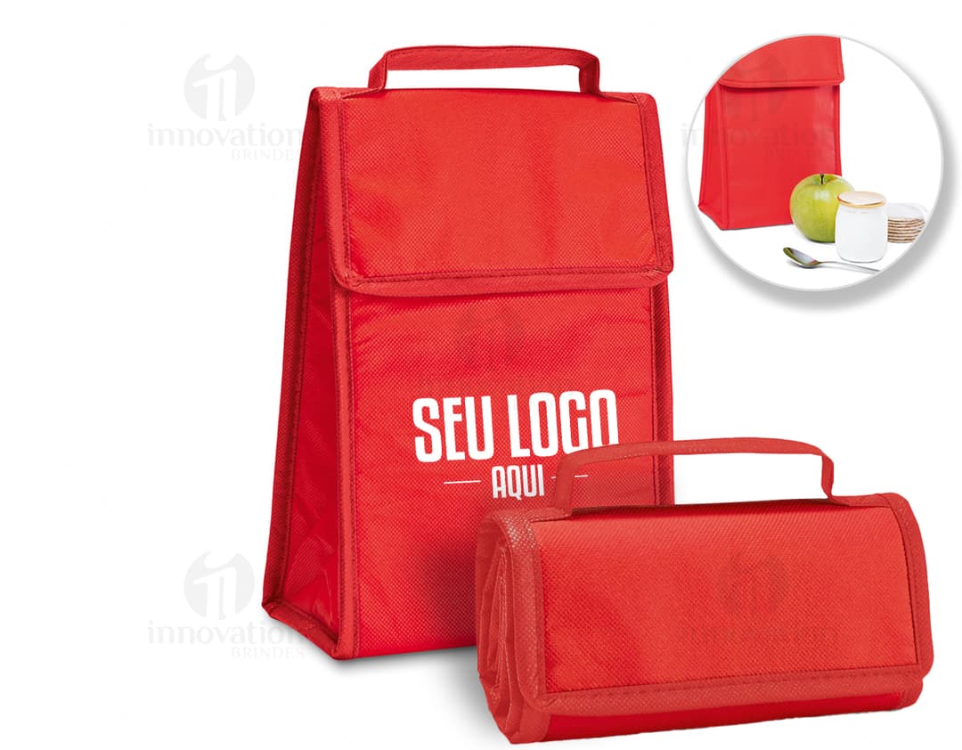 Bolsa térmica dobrável em formato 3D, vazia e aberta, com design moderno e clean. Está sobre uma mesa ao lado de um computador, um notebook e um dispenser de sabonete. A imagem contém elementos como embalagem de plástico, papel em branco, ícones de tecnologia e etiquetas de informação.