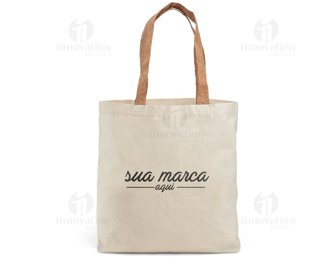 Sacola de algodão marrom com alças de cortiça, vazia e aberta. O design é elegante e moderno, perfeito para compras ou presentes. O material é resistente e possui um detalhe de padlock para segurança. A textura é vintage e grunge, dando um toque de estilo retro.