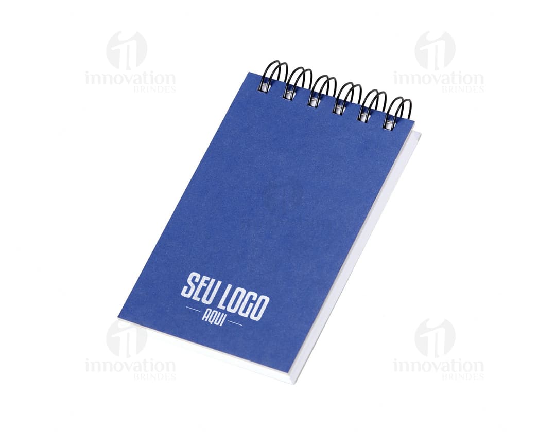 Envelope de papel bonito e colorido, com design em formato de container. O papel possui um símbolo vazio de presente e uma fita colorida em forma de laço. O objeto é um bloco de anotações com capa dura em Kraft, ideal para presentear em aniversários, celebrações, dia dos namorados e outras ocasiões especiais. O bloco é feito para escrever mensagens, lembretes e informações, com um visual moderno e atrativo.