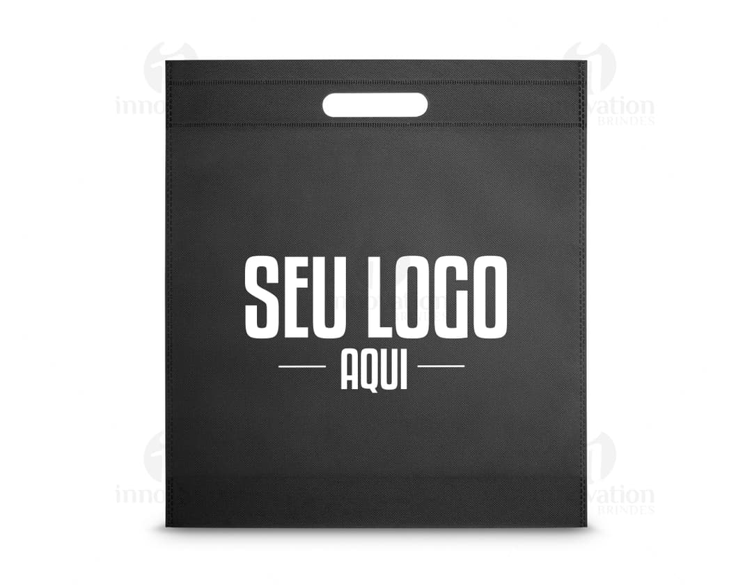 Envelope de papel em branco dentro de um container, sobre um papel de carta decorado, com um design vintage e bordas texturizadas. O ambiente é de um escritório vazio, com um notebook aberto ao lado da sacola de 355 x 390 mm. na cor rosa.