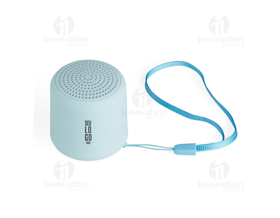 Caixa de som Bluetooth preta e prateada, com design moderno e compacto. Feita de material metálico e plástico, possui botões de controle, entrada USB e conexão sem fio. Ideal para uso em escritórios, em casa ou em ambientes corporativos.