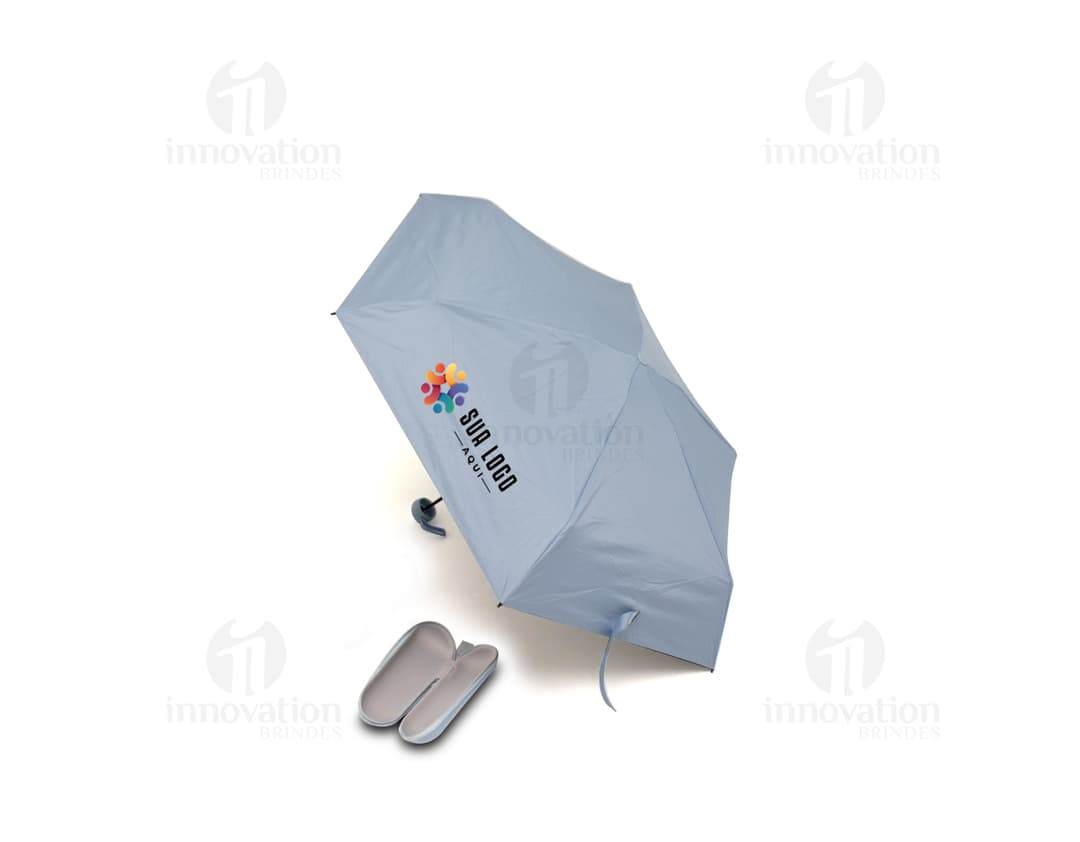 Guarda chuva manual sendo segurado por uma pessoa sorridente em um escritório moderno com um computador e monitor ao fundo. O guarda chuva é preto e está aberto, sugerindo proteção contra a chuva. A pessoa está vestindo roupas profissionais e parece feliz. A imagem transmite a ideia de segurança e conforto em dias chuvosos.