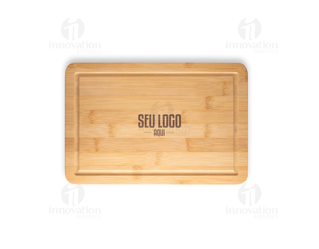 Tabua de corte em bambu em um bloco de madeira marrom vazio, com papel e caixa ao redor.