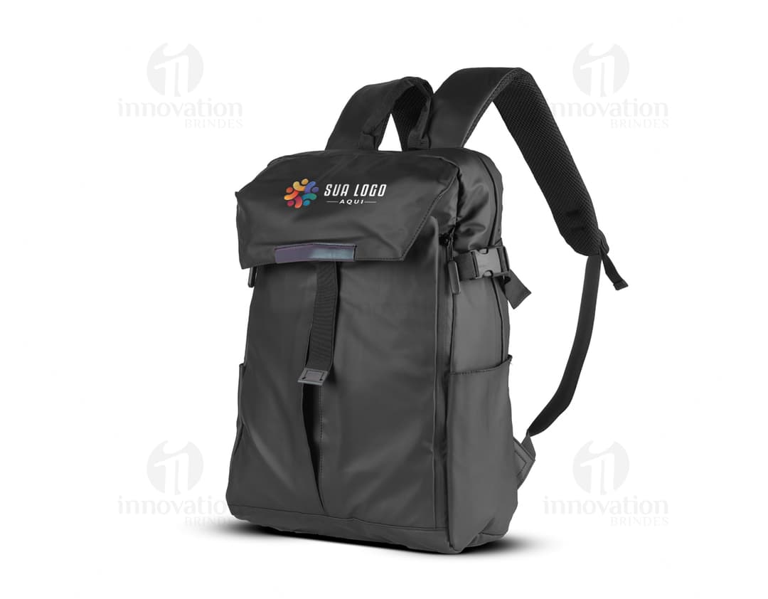 Mochila para Notebook preta de couro, sendo segurada por um homem de terno em um estúdio. Ele está sorrindo e segurando um fone de ouvido.