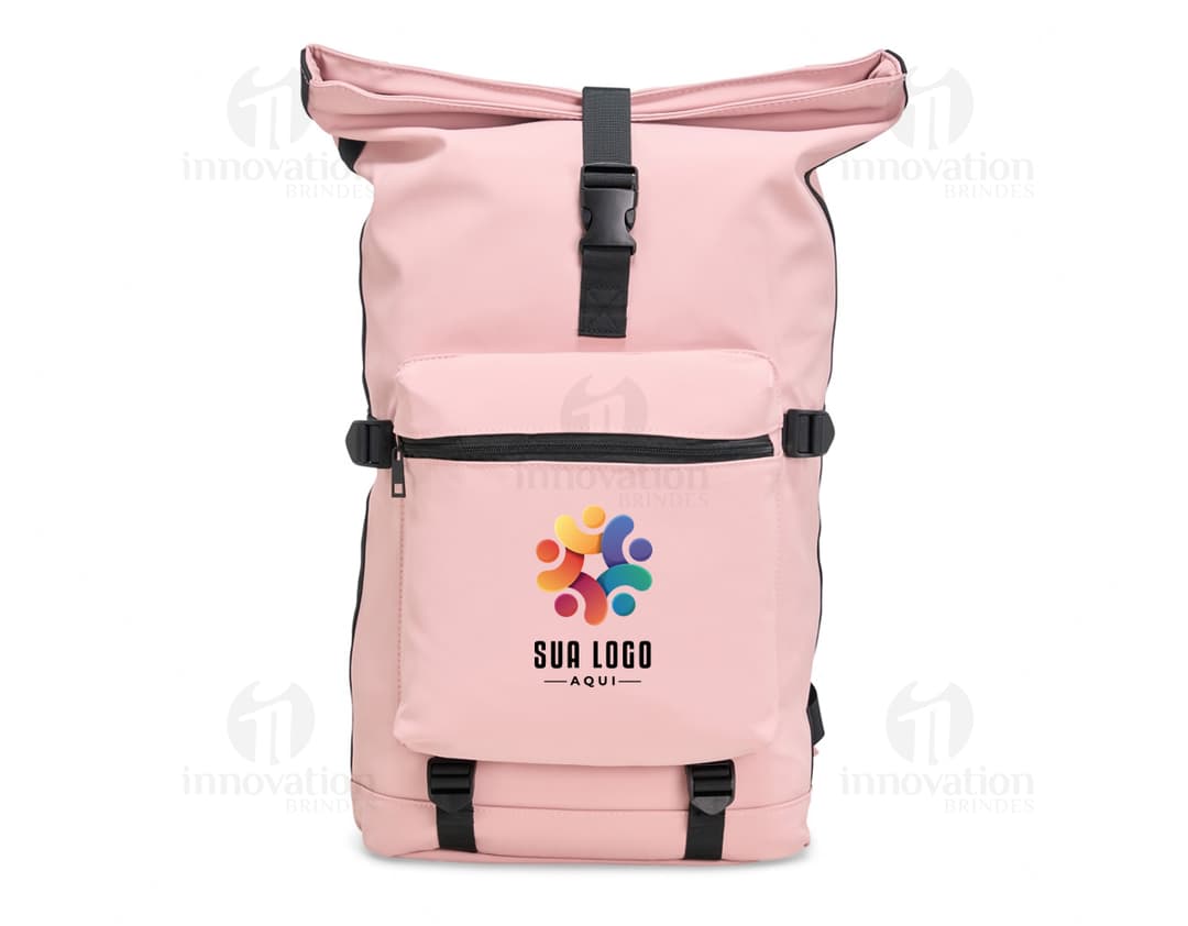 Homem de terno preto e gravata sorrindo enquanto segura uma mochila de couro sintético preta em um escritório. Ele está sentado em uma cadeira com um laptop aberto à sua frente. Atrás dele, uma mulher de negócios está trabalhando em um computador. Ambos parecem felizes e profissionais. O homem está sorrindo, e a mulher está concentrada. A imagem transmite um ambiente de sucesso e trabalho bem-sucedido.