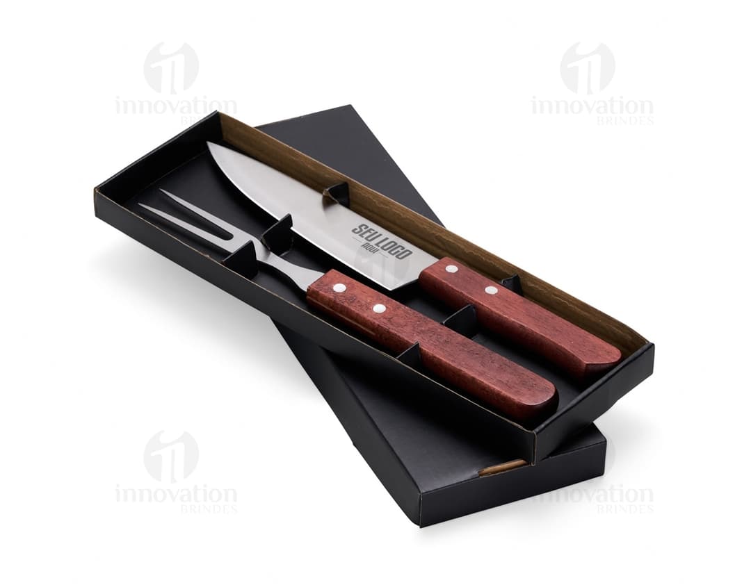 Um conjunto de dois utensílios de churrasco em aço inoxidável, incluindo faca e garfo. Os utensílios são de cor prata, com design clássico e acabamento brilhante. Perfeitos para uso em churrascos, com cabo de madeira para maior conforto durante o manuseio.