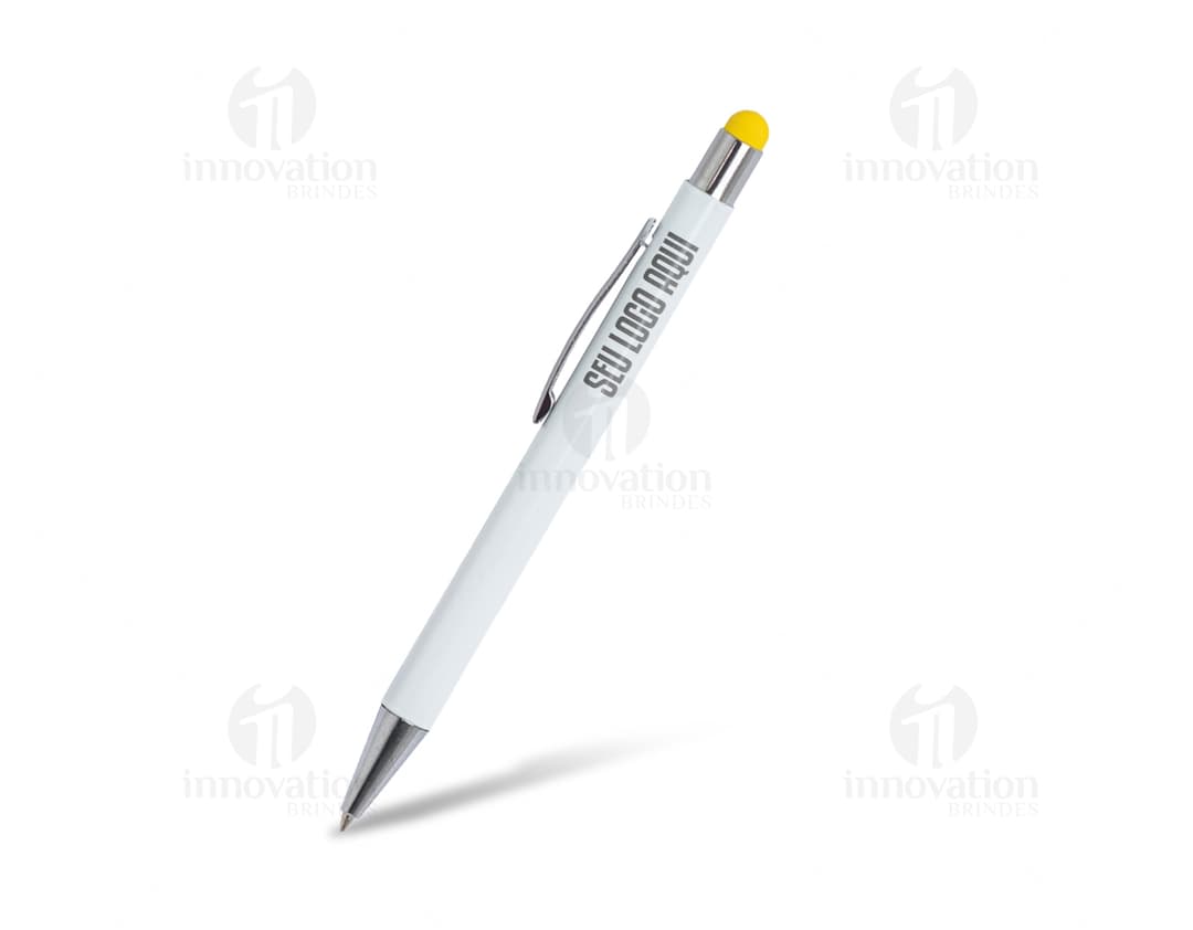 Caneta Metal Touch prateada sobre uma mesa de escritório, ao lado de um caderno, uma secretária e um lápis.