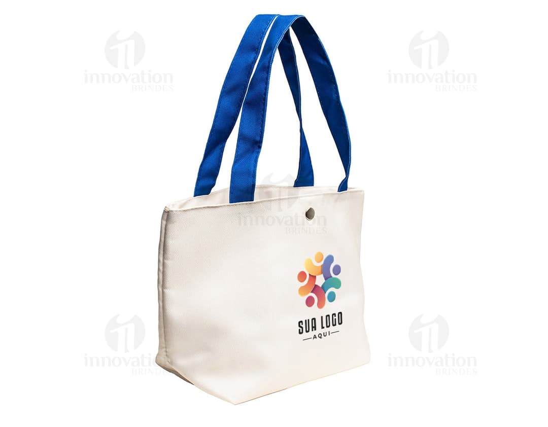 Bolsa de lona na cor azul-marinho com alças de couro marrom e fecho de zíper na parte superior.