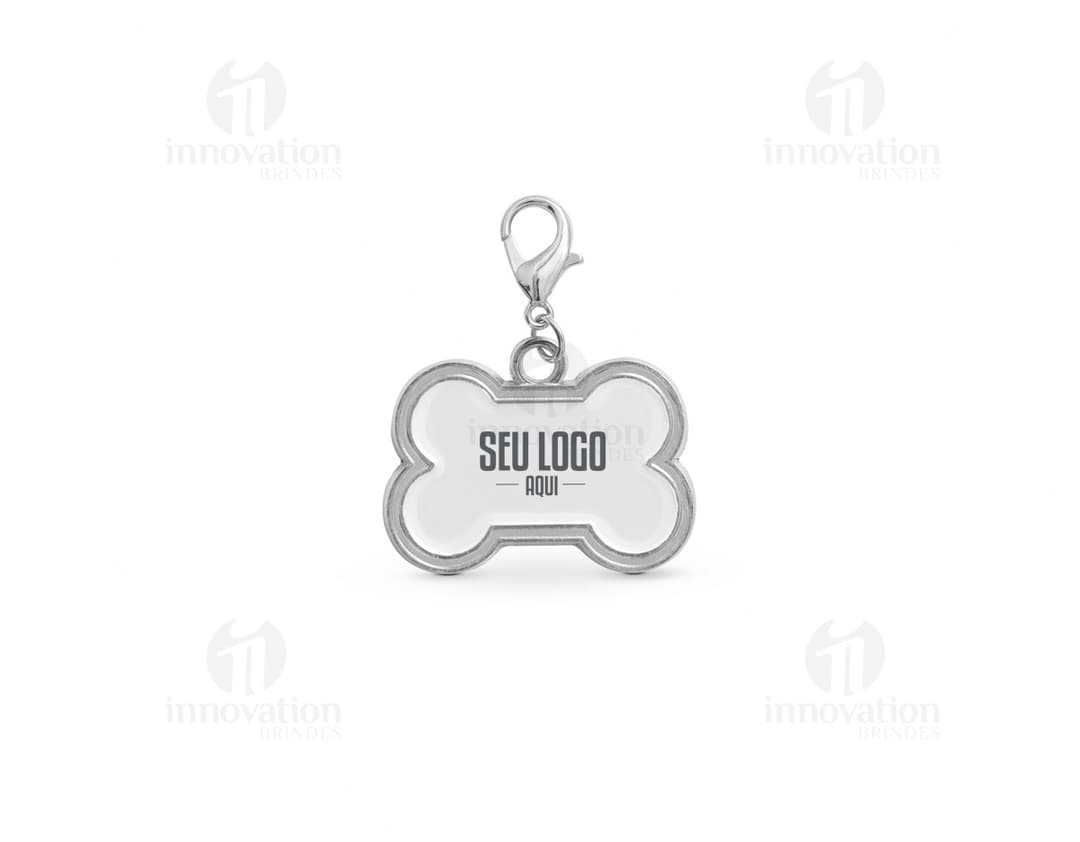 Chaveiro em formato de osso em cor prata com detalhes de patinhas.