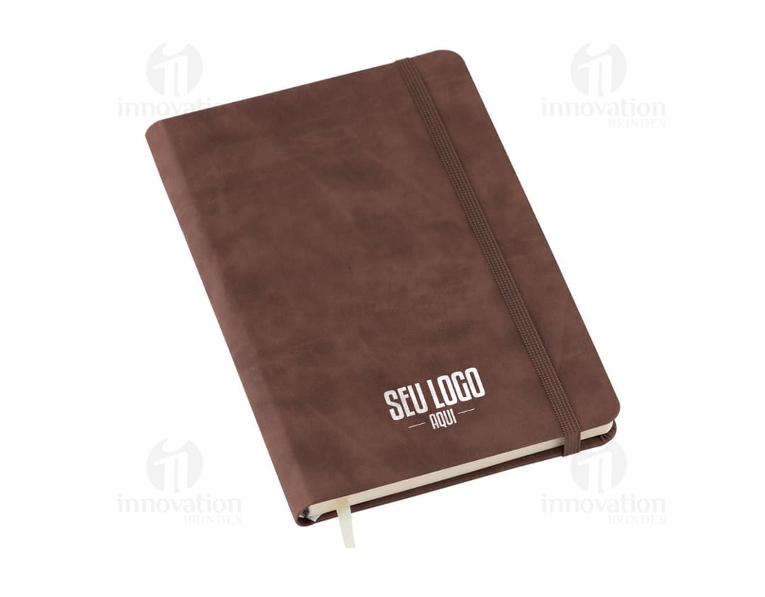 Caderneta sem pauta na cor azul, com capa dura e elástico para fechamento.