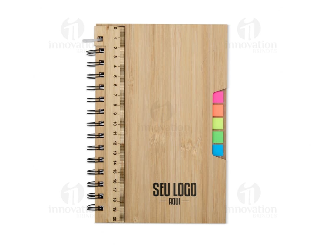Caderno A5 Bambu em textura de bambu, aberto e com páginas em branco. Possui régua de medição, instrumento de medição, notebook, papel, anotações, espaço para escrever e design clean. Ideal para estudo, trabalho ou projetos.