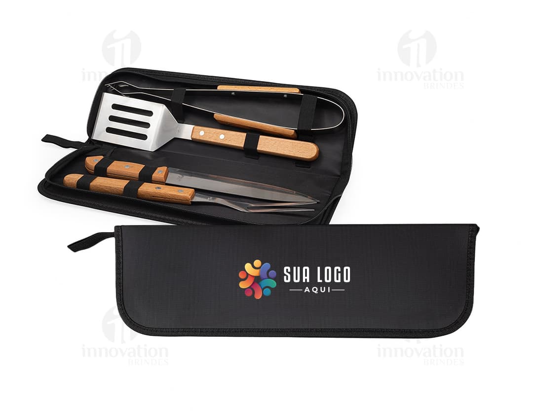 Kit churrasco 4 peças em caixa de couro preta contendo utensílios de metal e plástico, tais como faca, garfo, espátula e pegador. Ideal para uso em churrascos, com design moderno e prático.