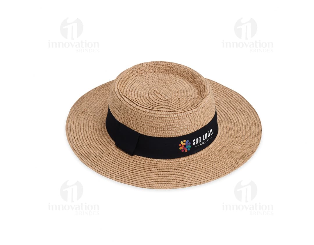 chapéu de palha em cor bege com fita marrom decorativa e aba larga; fundo de folhas verdes e céu azul ao fundo.