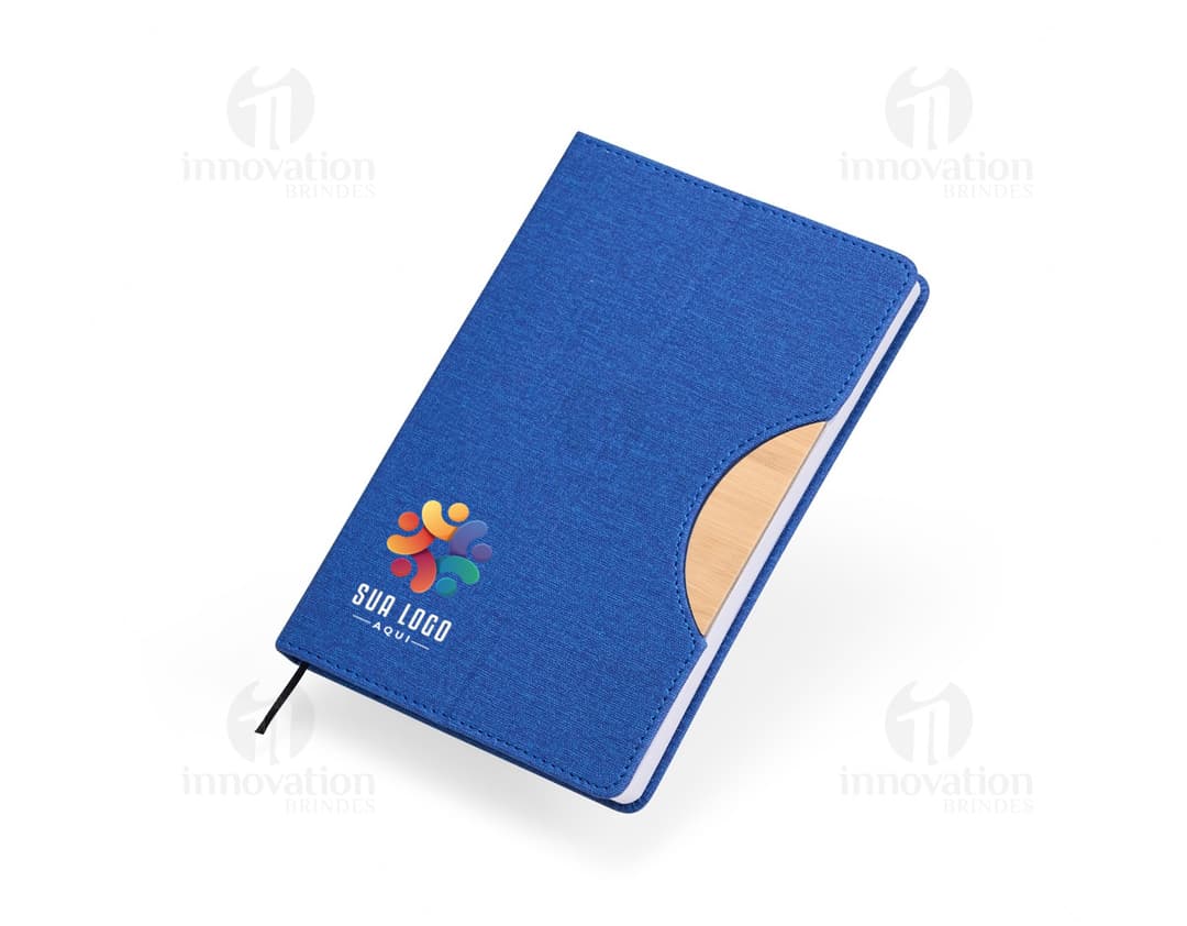 Caderneta com suporte de celular em uma mesa de escritório com notebook, papel em branco, cartão vazio, notas amarelas, livro, textos, padrões e texturas coloridas.