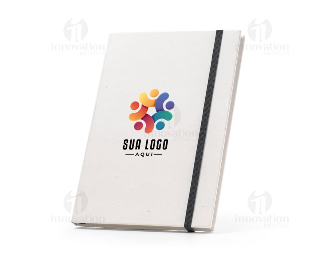 Caderno A5 Reciclado com capa dura marrom e elástico azul. Páginas lisas, feito de material reciclado.