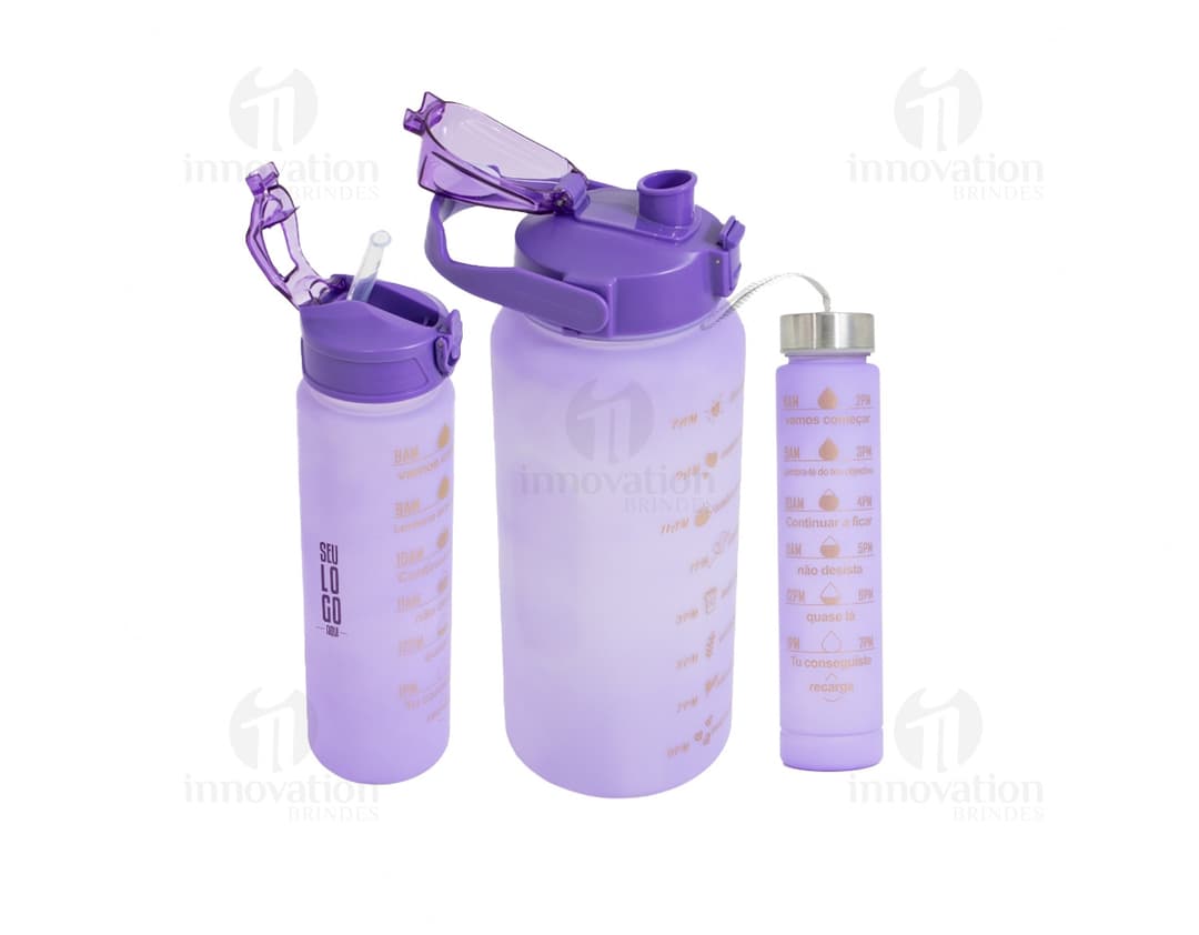 Três garrafas de vidro transparente, com tampa de metal prateada, dispostas lado a lado em uma superfície branca.