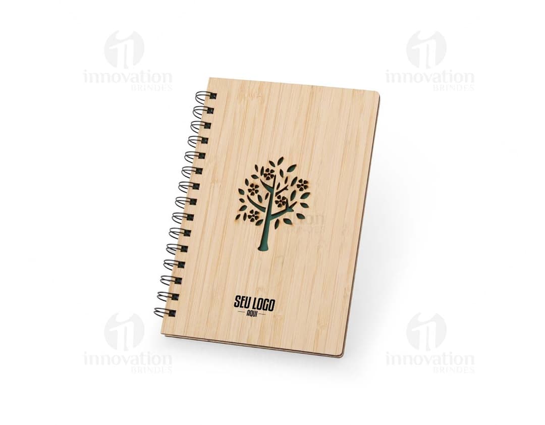 Caderno Bambu com capa de tecido estampado em tons de verde e marrom, folhas em papel reciclado e marcador de páginas de fita verde.