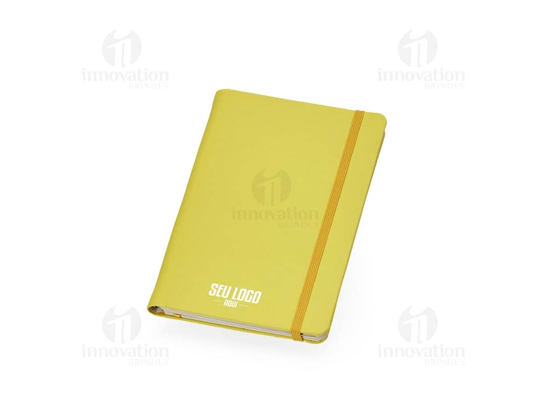 Caderneta Emborrachada com Wire-o em amarelo, design de quadro adesivo vazio em um notebook aberto, com papel em branco e um envelope de papel à direita, sobre fundo liso e limpo.