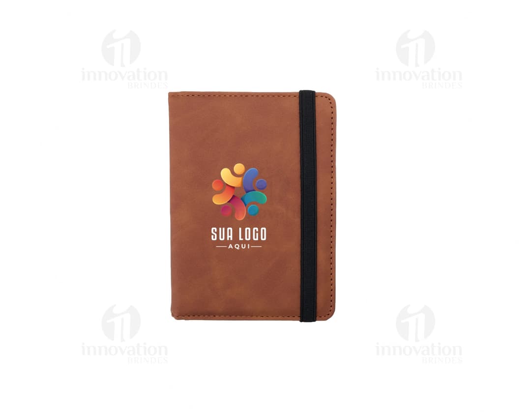 Envelope de papel antigo marrom com padrão vintage e textura retro, contendo um cartão em branco dentro de um bloco de papel. O envelope está sobre uma superfície de papelão texturizado, vintage e danificado, com um selo antigo. Ao redor, há um cenário de objetos de papelaria e decoração, como diferentes envelopes, cartões, dinheiro, livros, fitas e malas, em tons de amarelo, rosa e marrom.