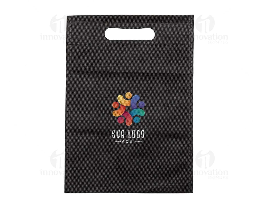 Carteira preta, bolsa de papelão vazia, notebook com quadro negro ao fundo, antigo cartão de memória em cima de um caderno de couro marrom.