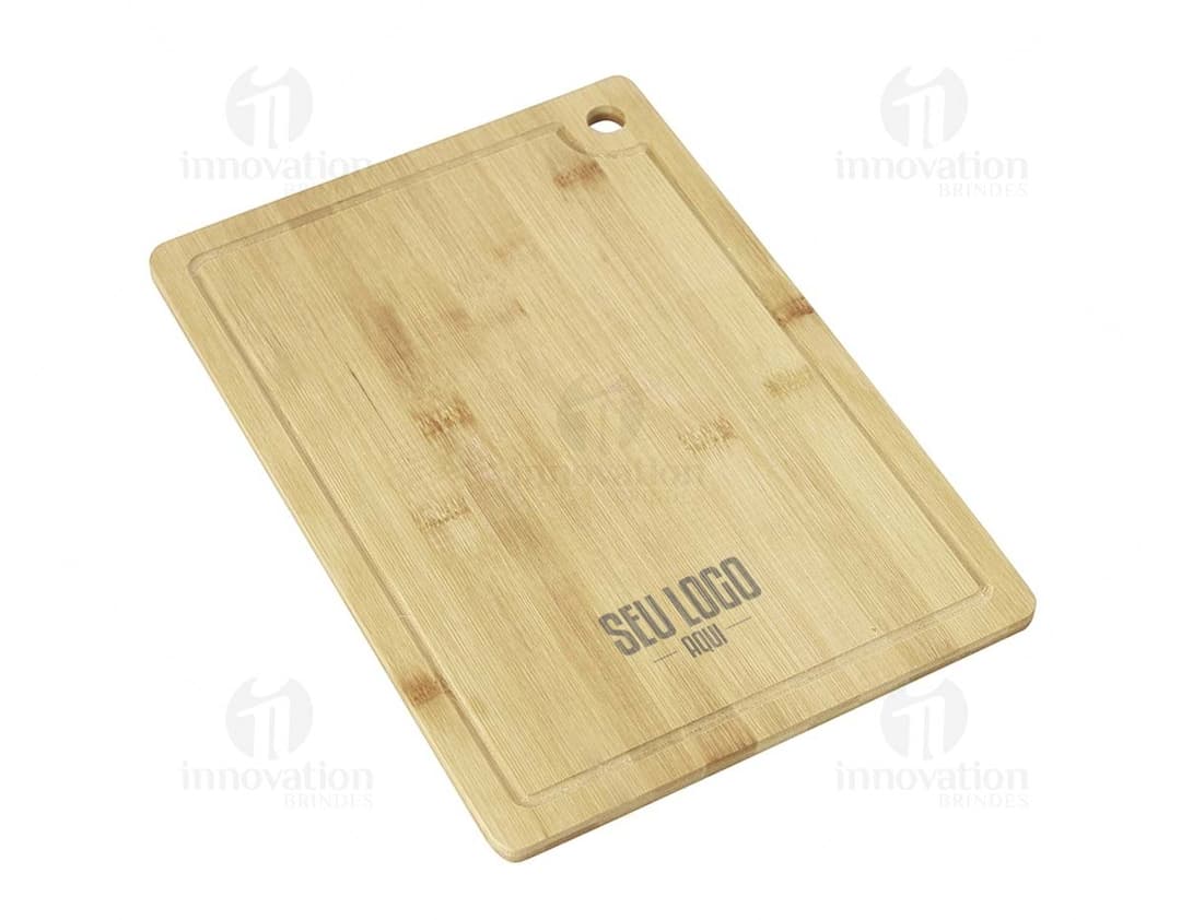 tábua de corte com canaleta, feita em madeira,  possui dimensões retangulares e apresenta sulcos para evitar o escorrimento de líquidos durante o corte de alimentos.