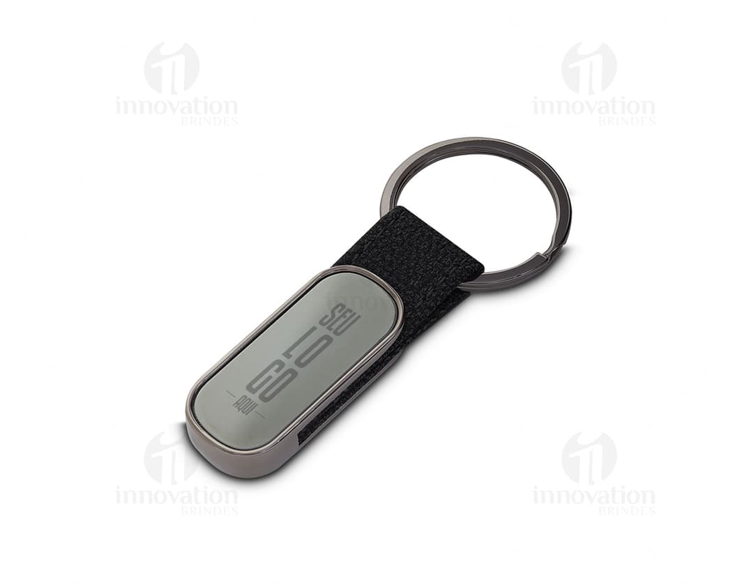 Chaveiro de metal moderno e elegante em formato de telefone celular, com tela digital e teclado. O dispositivo possui botões de comunicação e é feito de couro, na cor preta e prata.