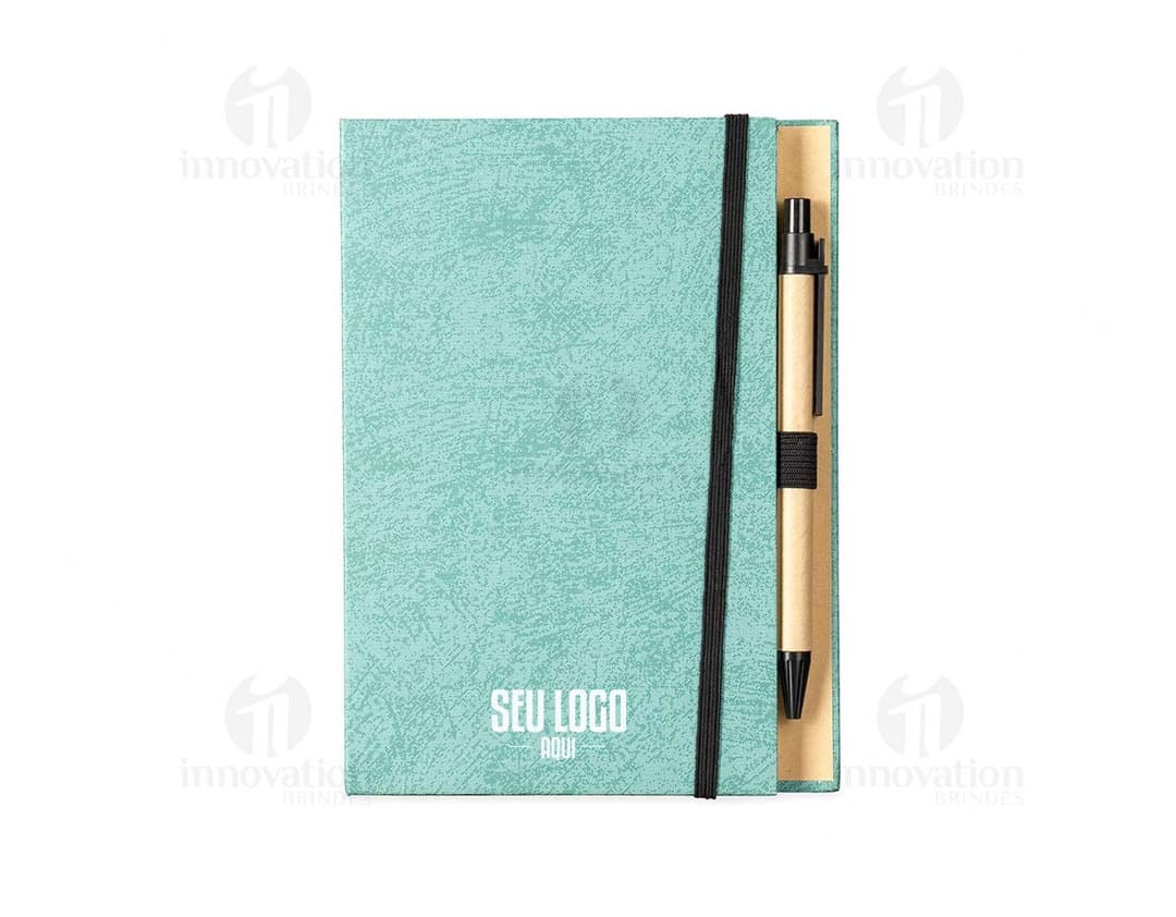 Bloco de anotações em papel reciclado com capa marrom e elástico azul, sobre uma mesa de madeira.