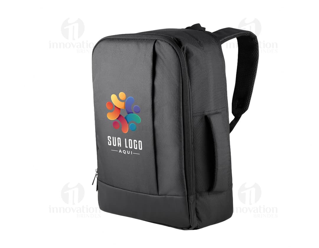 Homem de terno preto e pasta executiva, segurando uma mochila preta nas costas, em um ambiente corporativo.