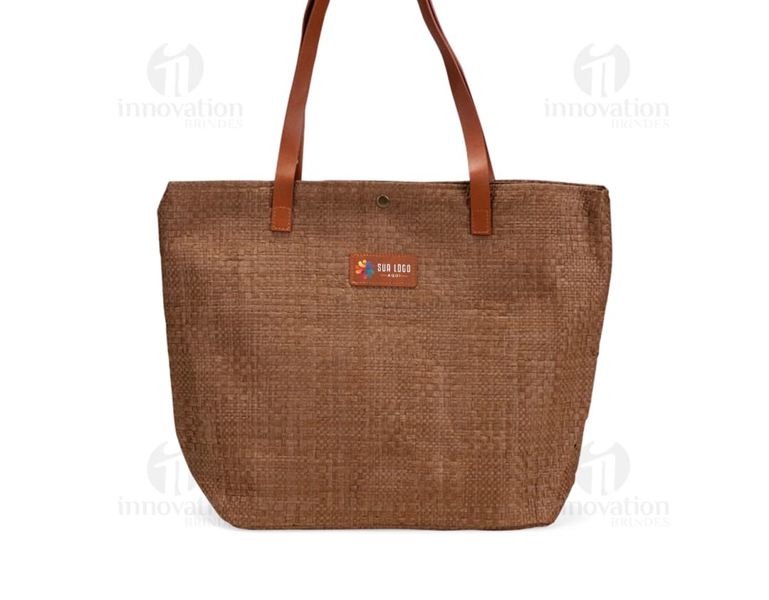 Bolsa de palha trançada marrom, elegante e moderna, com alça de couro, fecho de zíper, detalhes em metal, design vazado, e textura trançada. Ideal para um look casual e sofisticado.